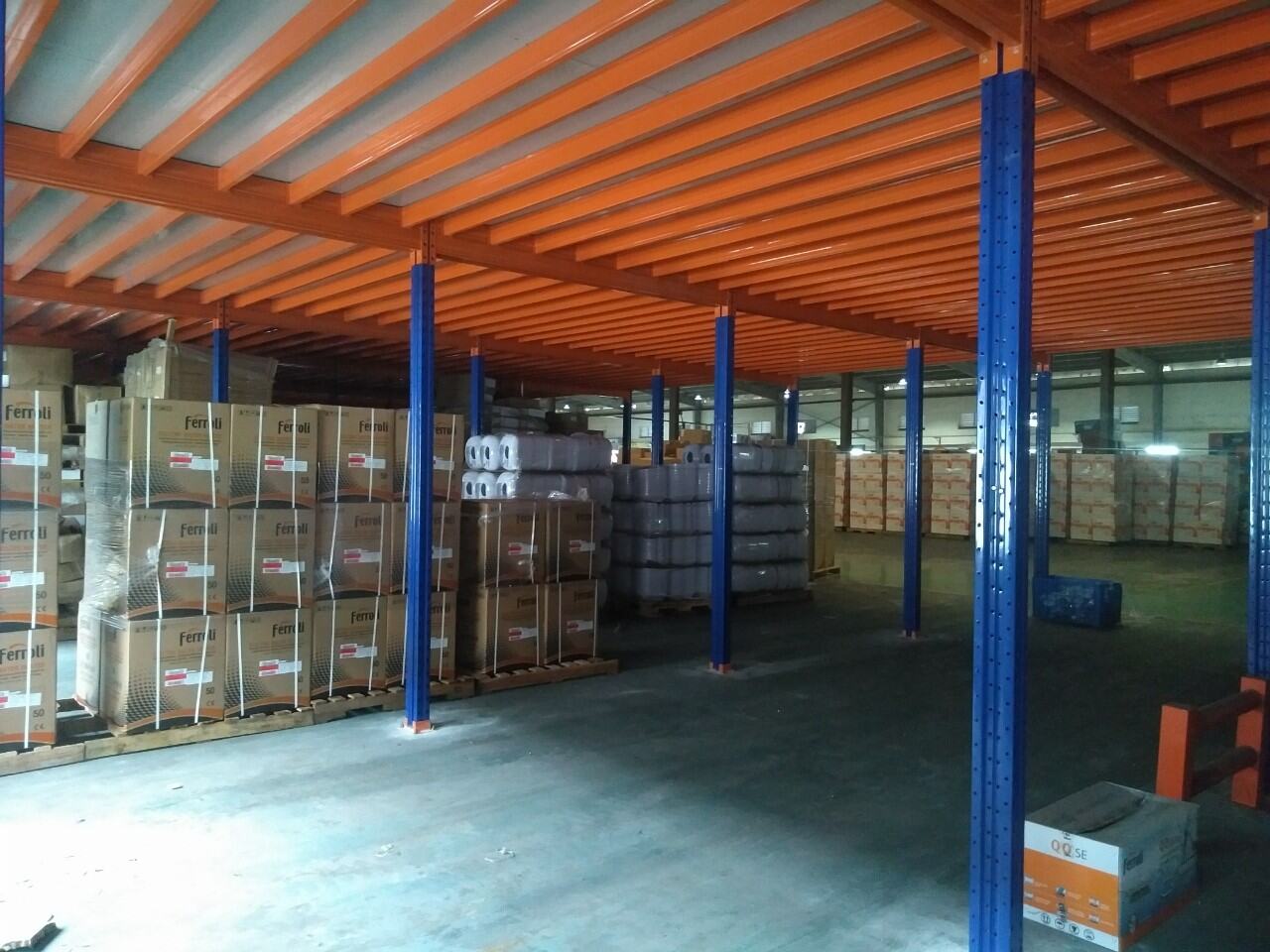 Gầm sàn tầng lửng thép với hệ dầm sơn cam, tận dụng không gian bên dưới làm khu chứa hàng tại kho Ferroli Asean