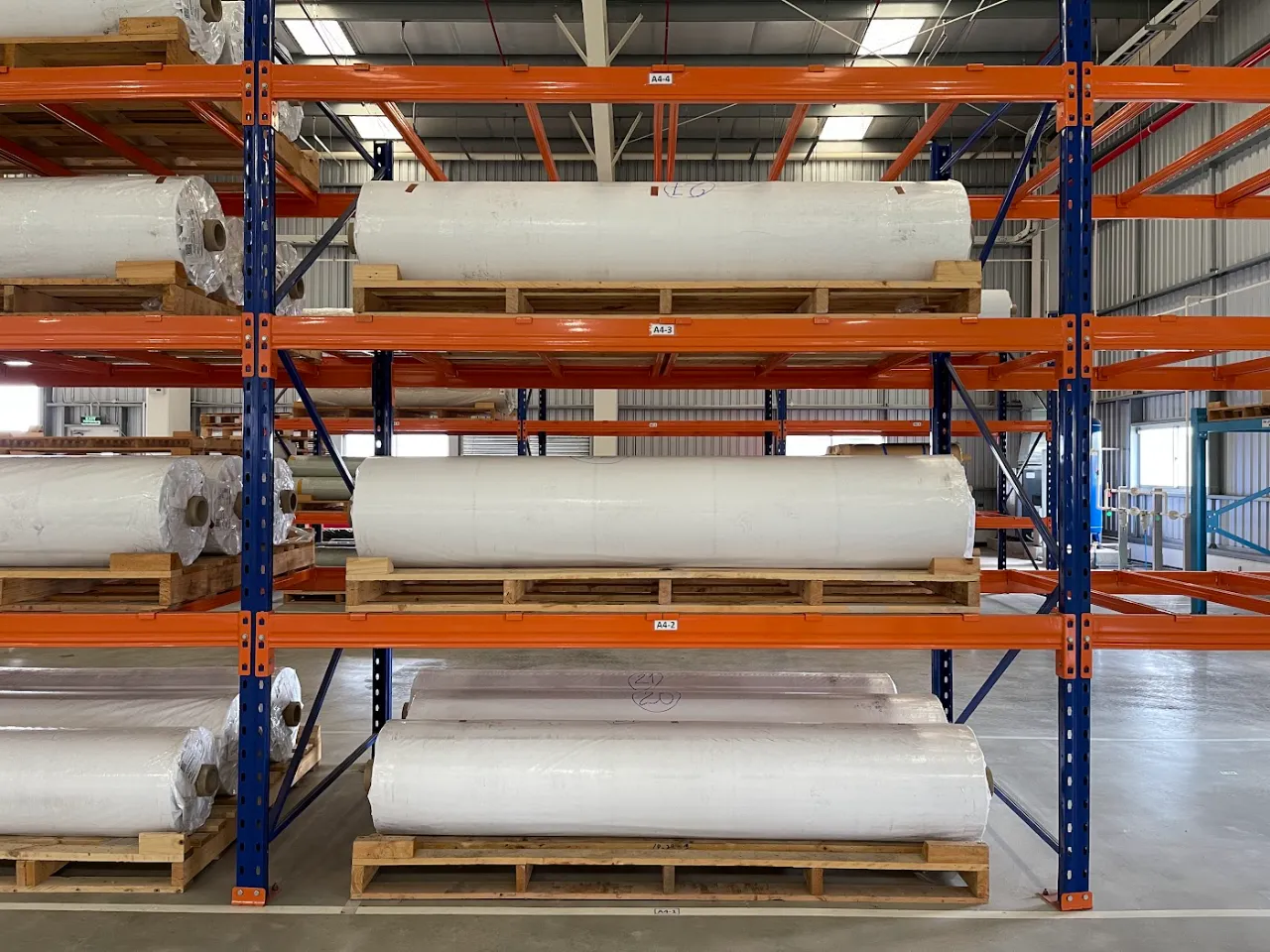 Cuộn vật liệu đặt trên pallet gỗ ở các tầng kệ selective