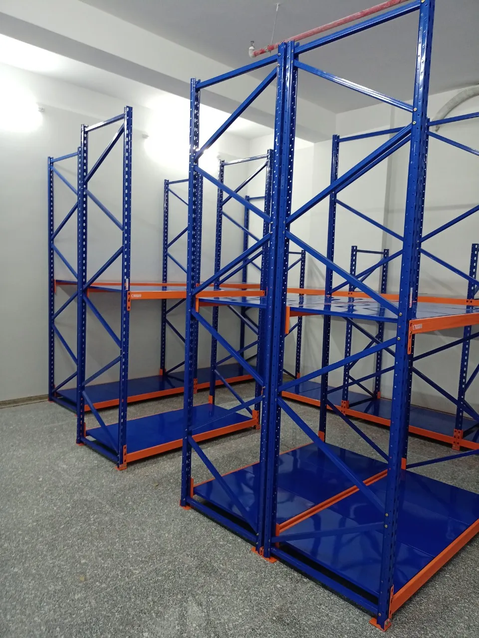 Dãy kệ thép sơn tĩnh điện xanh cam đặt trong phòng lạnh trước khi đưa hàng vào