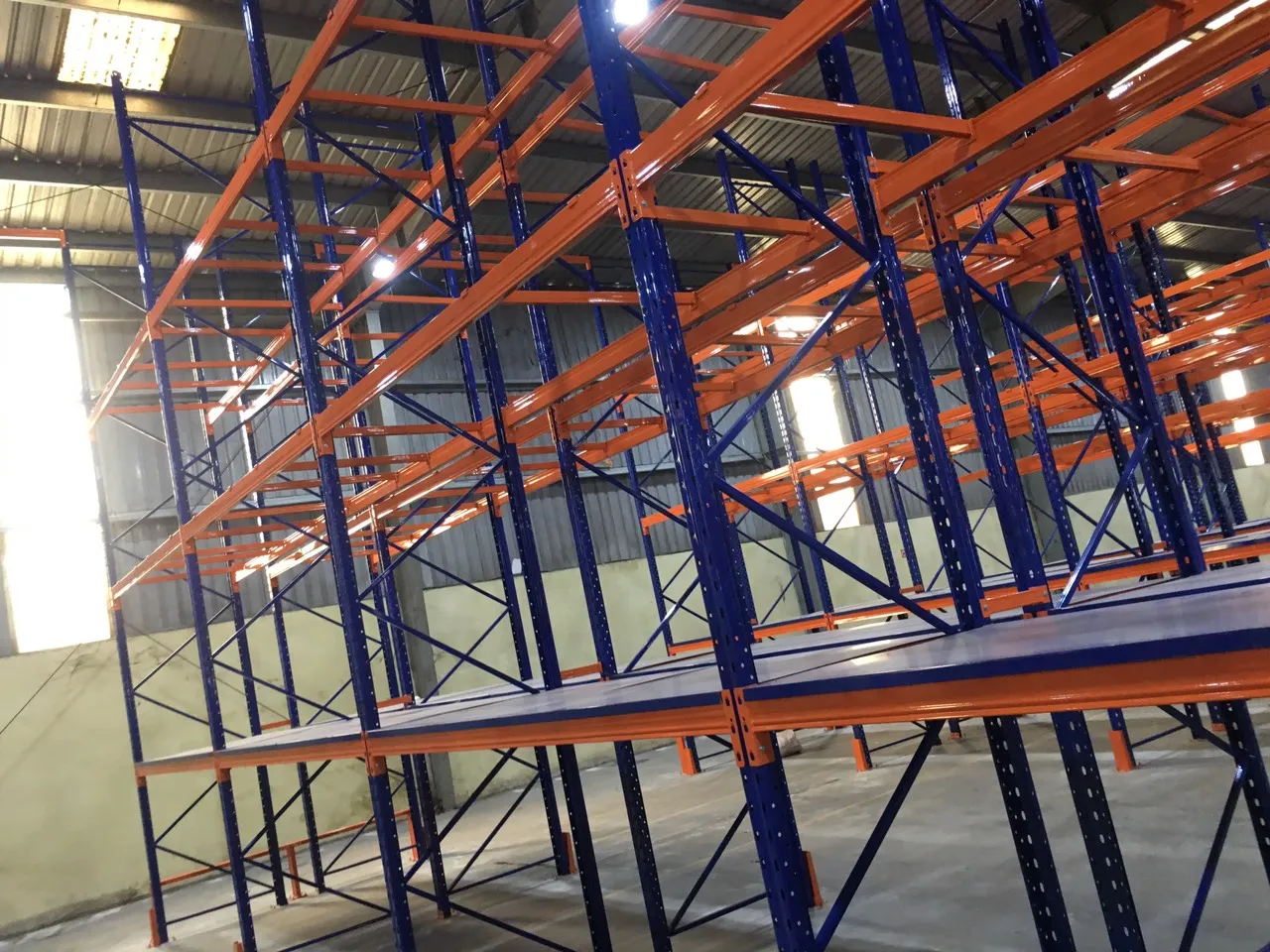 Góc nhìn từ dưới lên hệ kệ pallet cao, thể hiện khoảng hở giữa đỉnh kệ và mái nhà kho