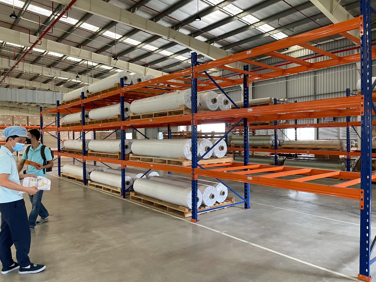 Nhân viên kho đối chiếu hàng hóa với vị trí trên kệ pallet