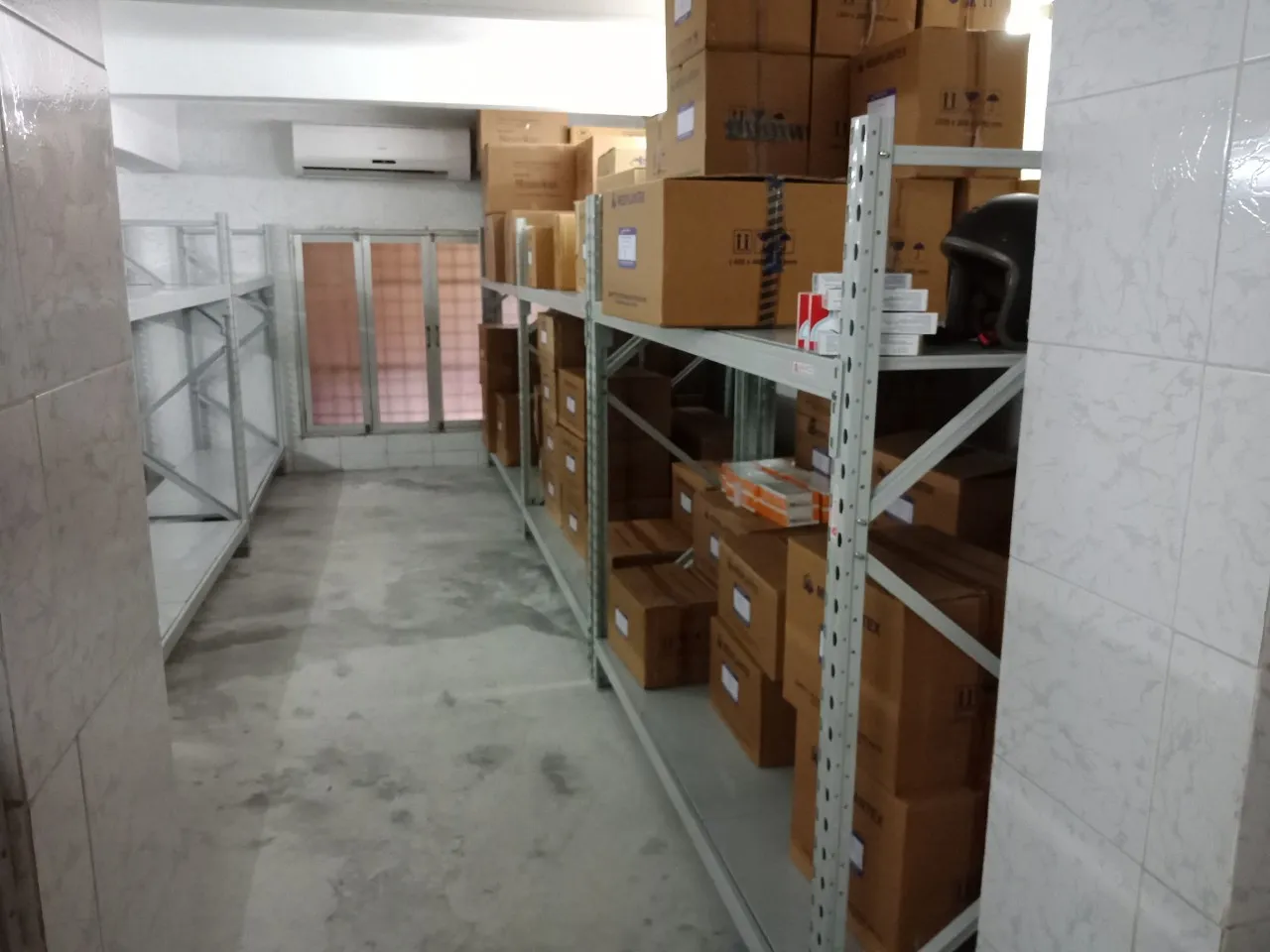 Lối đi giữa hai dãy kệ trung tải chứa thùng thuốc trong khu bảo quản nhiệt độ thường