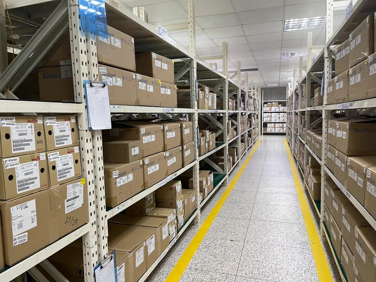 Medium-duty shelving aisle with labelled cartons and yellow floor markings