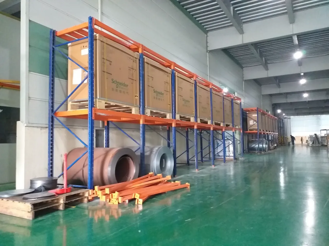 Selective pallet racking storing crated goods in a factory warehouse with epoxy floor