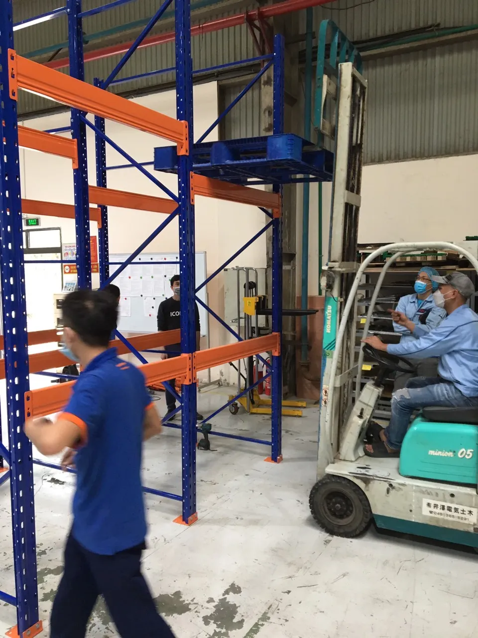Xe nâng đối trọng đặt pallet lên tầng kệ selective trong lúc bàn giao kho