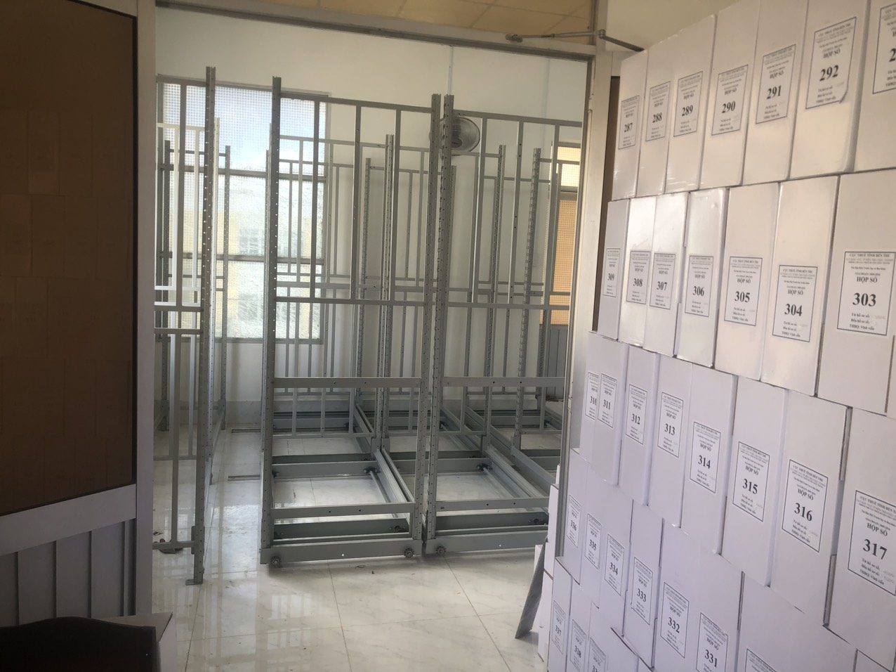 Hộp hồ sơ và tài liệu dán nhãn xếp gọn trên tủ hồ sơ di động